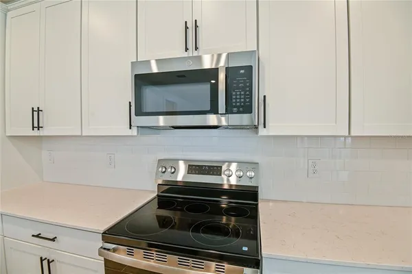 a kitchen with stainless steel appliances a stove and a microwave