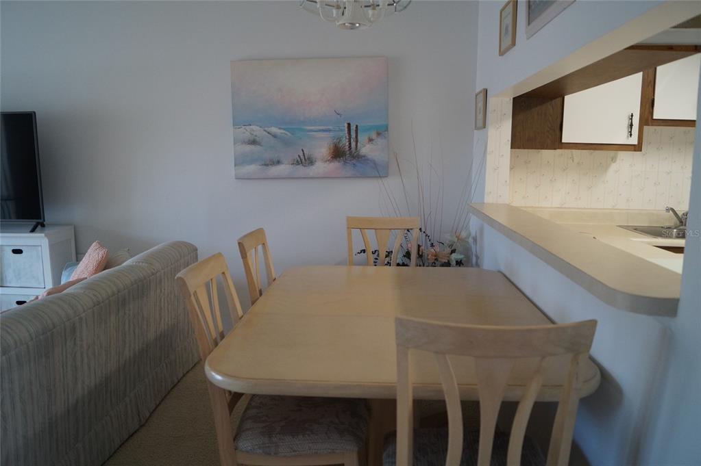 7701 Starkey Road, Unit 408 Seminole, FL 33777 - Photo 11 of 28 a dining room with furniture and a flat screen tv