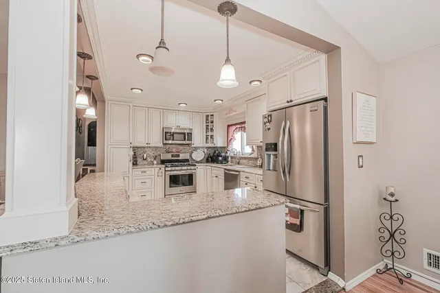 a kitchen with stainless steel appliances granite countertop a refrigerator a sink and a stove