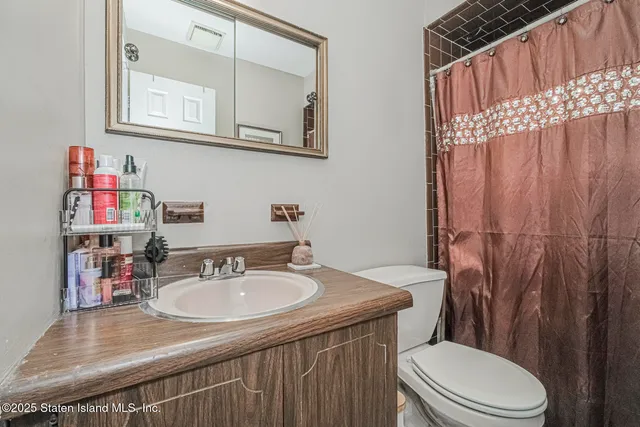 a bathroom with a sink a toilet and shower curtain