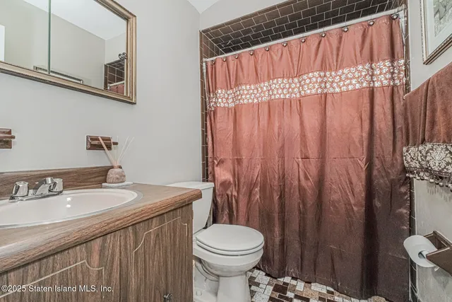 a bathroom with a sink a toilet and shower curtain