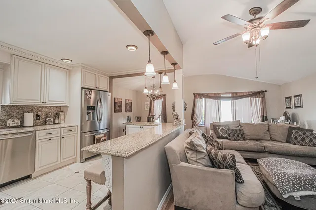 a living room with stainless steel appliances kitchen island granite countertop furniture and a kitchen view