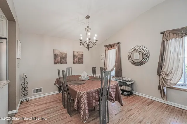 a view of a dining room with furniture a chandelier and wooden floor