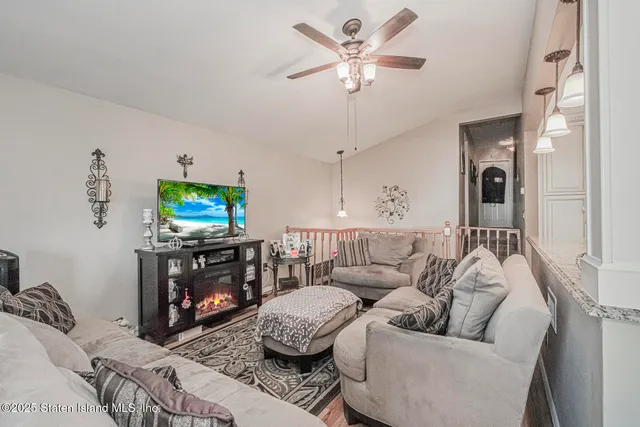 a living room with furniture a flat screen tv and a fireplace
