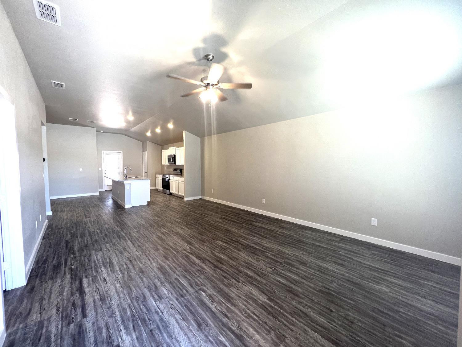 13705 Avenue Q Lubbock, TX 79423 - Photo 2 of 13 a view of a room with wooden floor and a ceiling fan