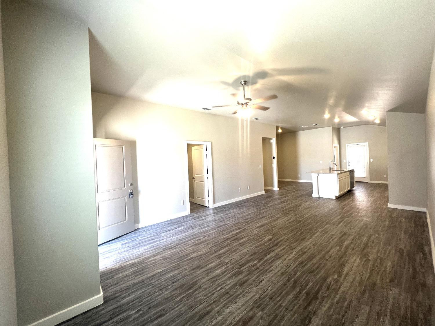 13705 Avenue Q Lubbock, TX 79423 - Photo 3 of 13 a view of a big room with wooden floor and a window