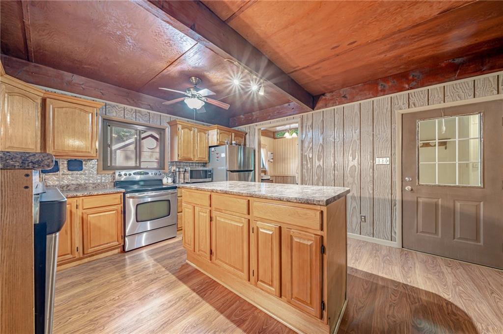 218 Horse Shoe Bend Road Acme, PA 15610 - Photo 4 of 31 a kitchen with stainless steel appliances granite countertop a stove a sink dishwasher and a refrigerator with wooden cabinets