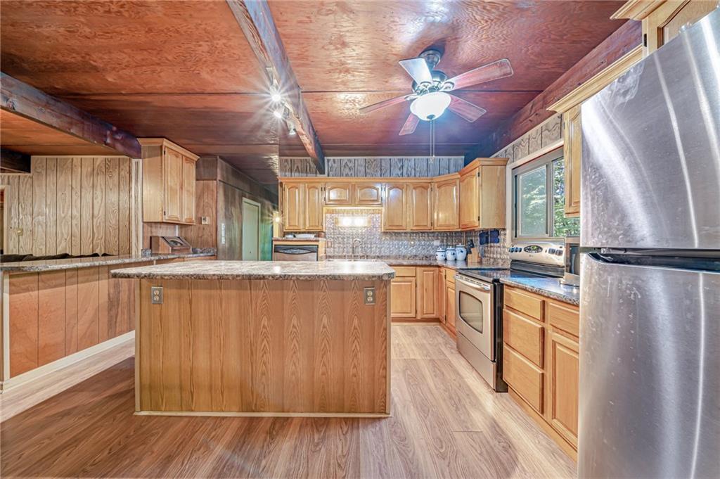 218 Horse Shoe Bend Road Acme, PA 15610 - Photo 6 of 31 a kitchen with stainless steel appliances granite countertop a refrigerator a sink dishwasher a stove and white countertops with wooden floor