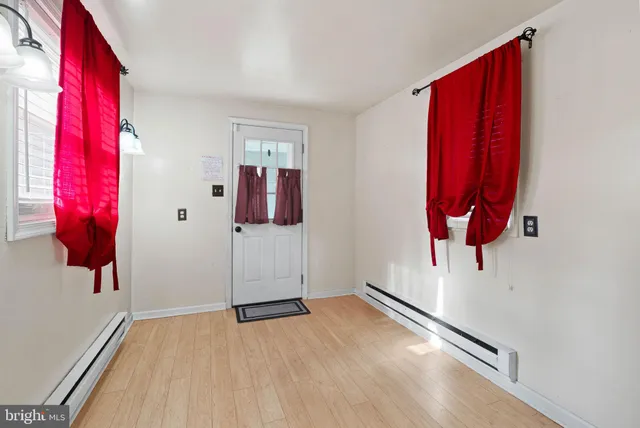 a view of a room with wooden floor and door