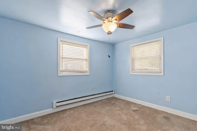 an empty room with a window and a ceiling fan