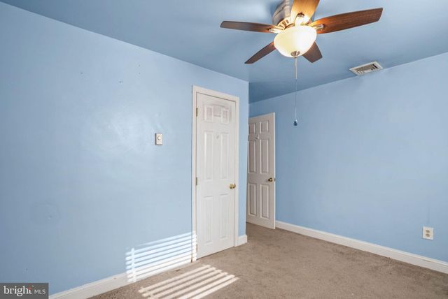an empty room with closet and a chandelier fan