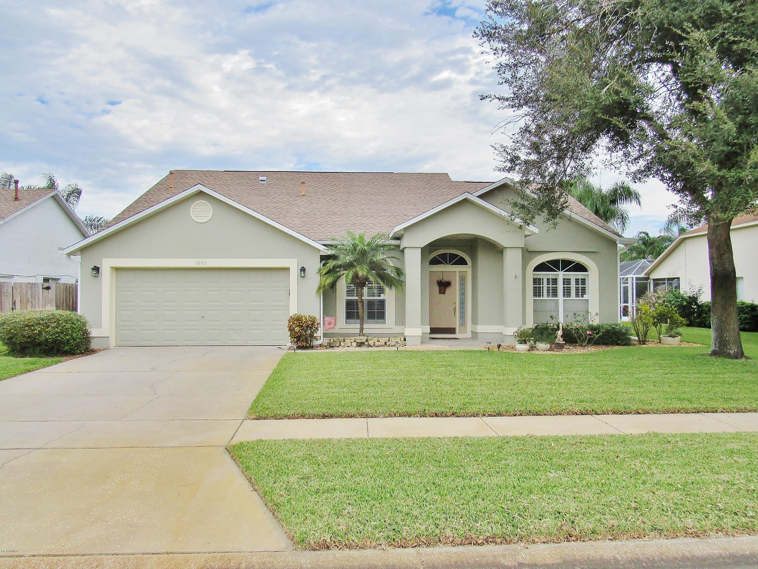 a front view of a house with a garden and trees
