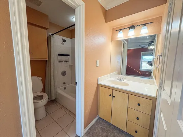 a bathroom with a granite countertop sink mirror and a toilet