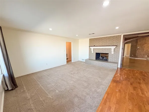 wooden floor with a fireplace in room