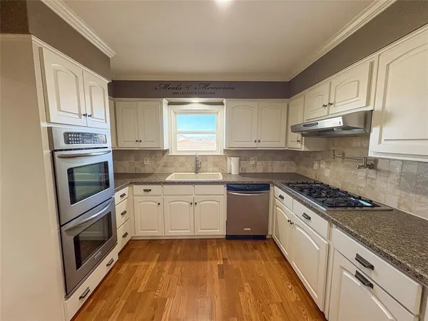 a kitchen with granite countertop cabinets stainless steel appliances and a window
