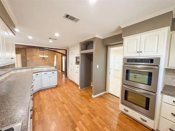 a kitchen with stainless steel appliances granite countertop a refrigerator and a stove top oven