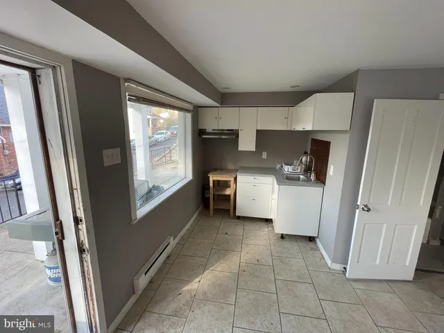 a kitchen with a refrigerator a stove top oven and cabinets