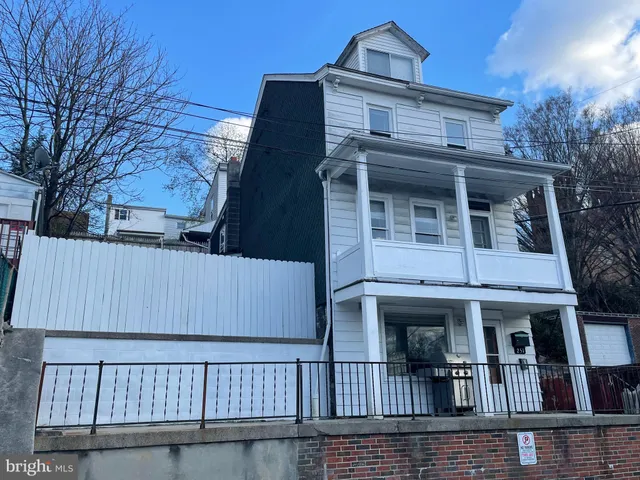 a view of a brick house with large windows and a small yard