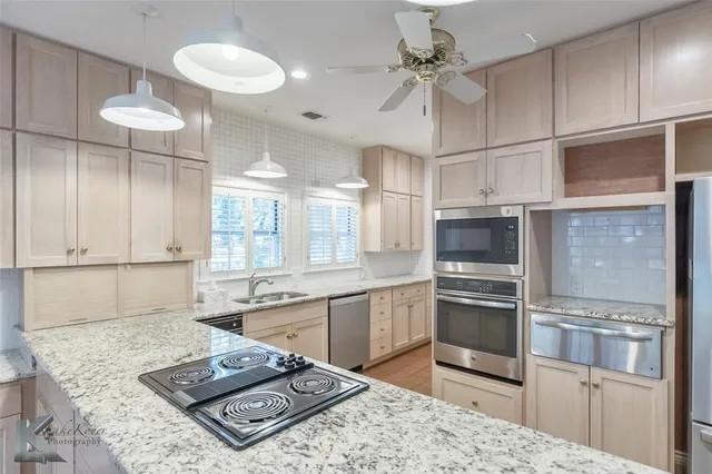 a kitchen with stainless steel appliances granite countertop a sink stove and refrigerator