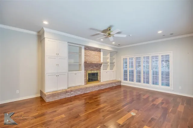 a view of an empty room with a fireplace and a window
