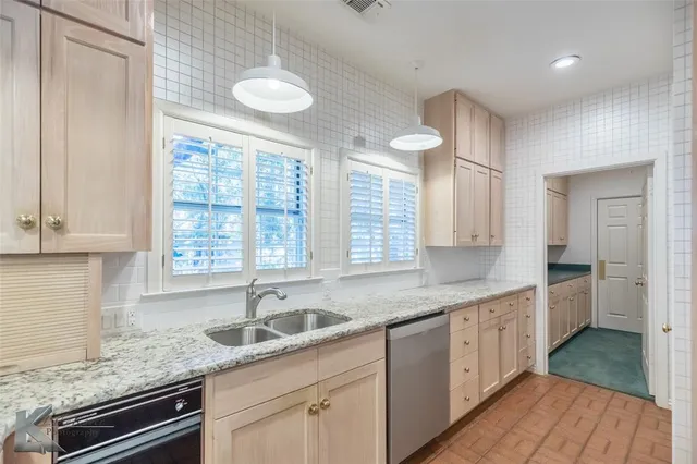 a kitchen with a sink dishwasher a stove and white cabinets with wooden floor