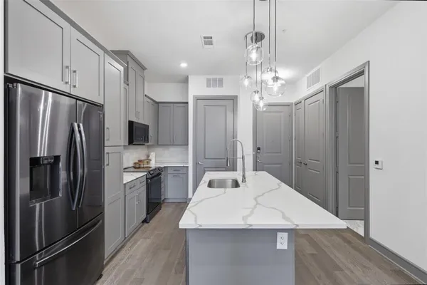 a kitchen with stainless steel appliances a refrigerator sink and microwave