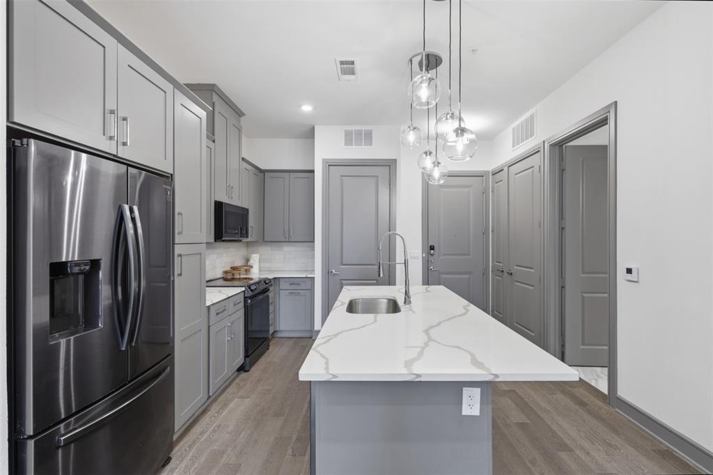 2700 Old Denton Road, Unit 2272 Carrollton, TX 75007 - Photo 1 of 40 a kitchen with stainless steel appliances a refrigerator sink and microwave