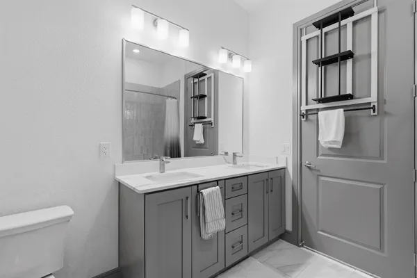 a bathroom with a sink a toilet and shower