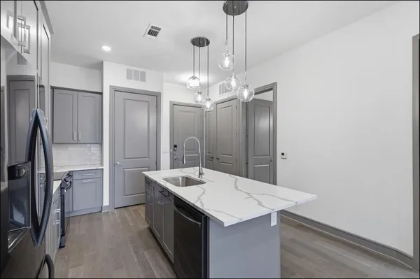 a kitchen with a sink a counter space and stainless steel appliances