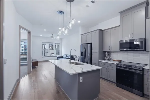 a kitchen with stainless steel appliances granite countertop a sink stove and refrigerator