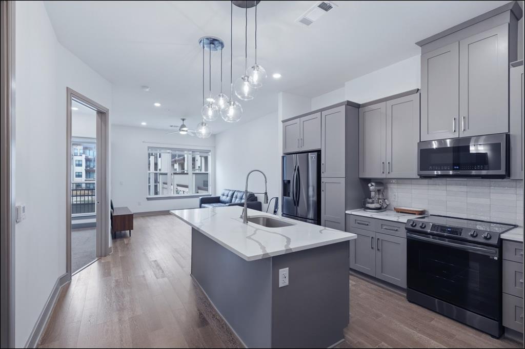 2700 Old Denton Road, Unit 2272 Carrollton, TX 75007 - Photo 4 of 40 a kitchen with stainless steel appliances granite countertop a sink stove and refrigerator