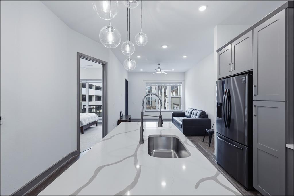 2700 Old Denton Road, Unit 2272 Carrollton, TX 75007 - Photo 5 of 40 a kitchen with a refrigerator a sink dishwasher a dining table and chairs with wooden floor