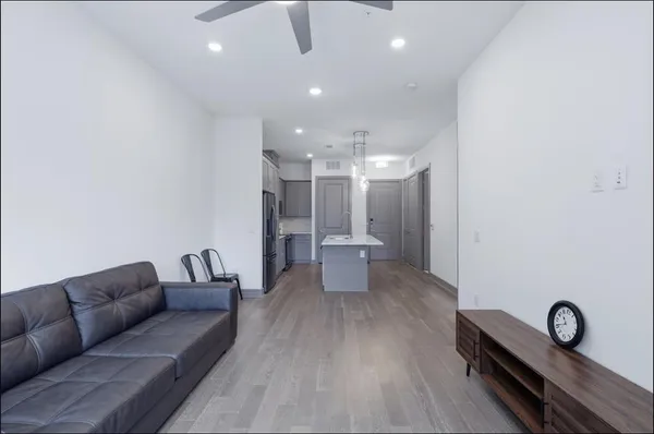 a living room with furniture a table and kitchen view