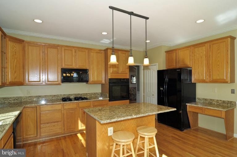 2135 Misty Meadow Road Finksburg, MD 21048 - Photo 20 of 27 a kitchen with stainless steel appliances granite countertop a refrigerator a stove a sink dishwasher and a microwave with wooden floor