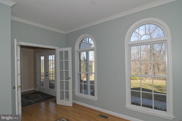 2135 Misty Meadow Road Finksburg, MD 21048 - Photo 3 of 27 an empty room with wooden floor chandelier and windows