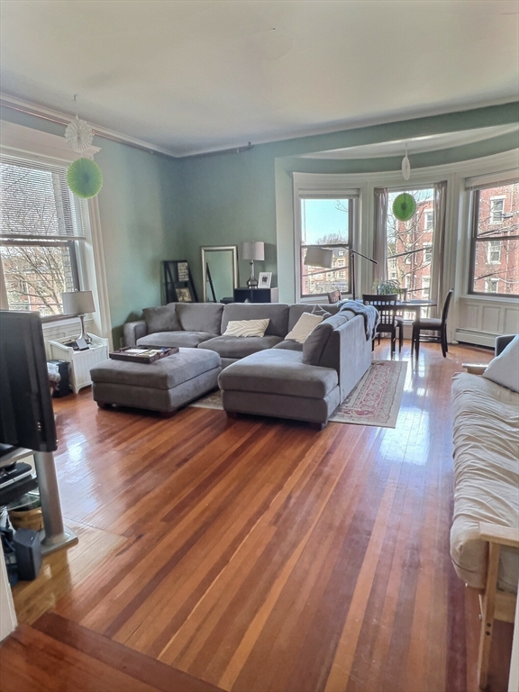 25 Garrison Road, Unit 1R Brookline, MA 02445 - Photo 2 of 5 a living room with fireplace furniture and a wooden floor