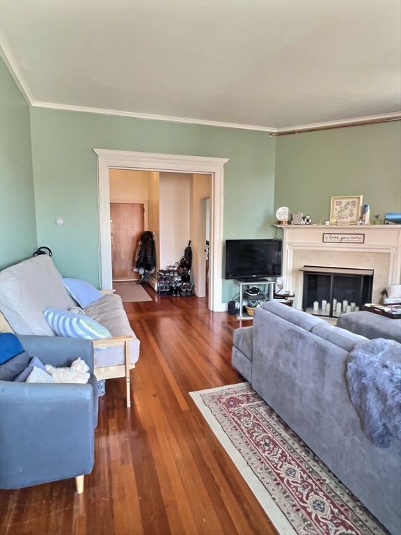 25 Garrison Road, Unit 1R Brookline, MA 02445 - Photo 3 of 5 a living room with furniture a fireplace and a flat screen tv