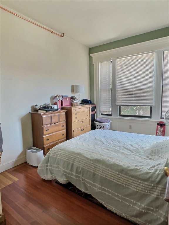 25 Garrison Road, Unit 1R Brookline, MA 02445 - Photo 4 of 5 a bedroom with a bed and wooden floor