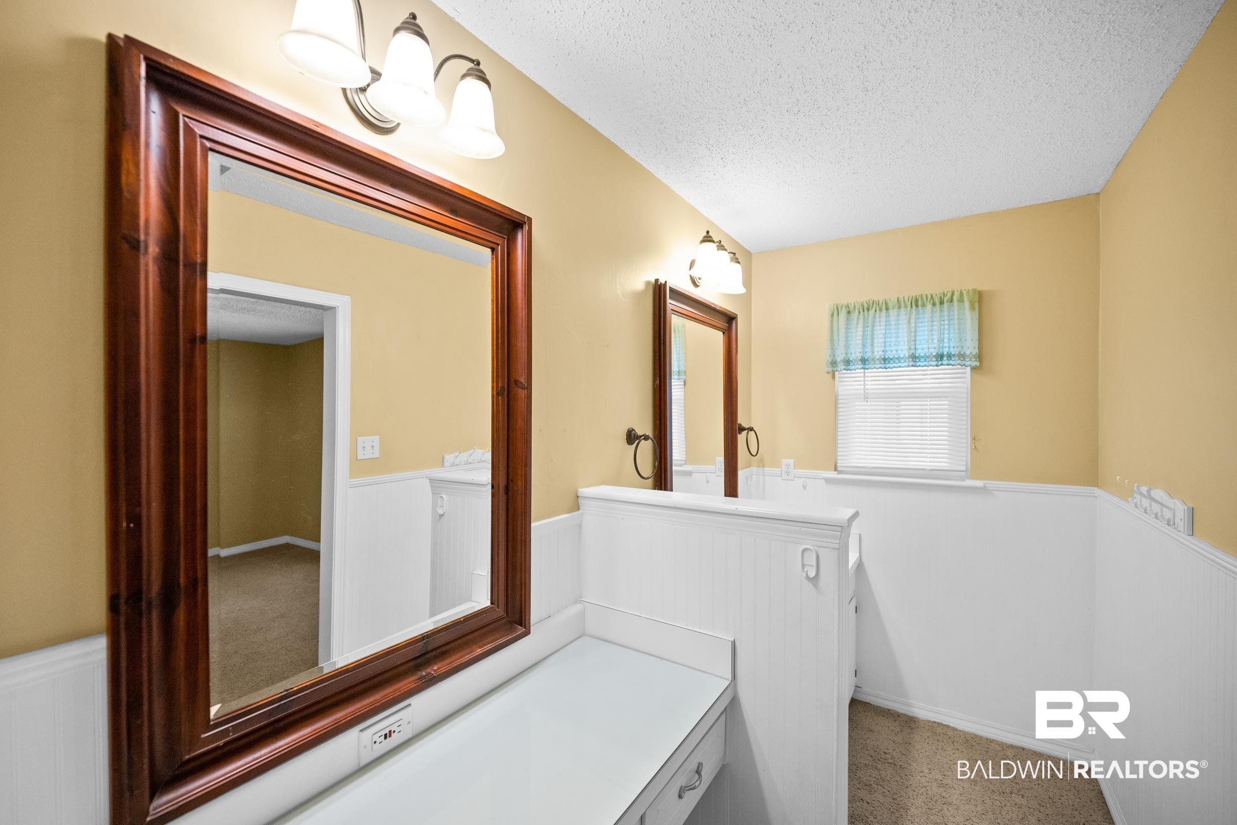 123 Dunbar Loop Daphne, AL 36526 - Photo 16 of 33 Bathroom featuring wainscoting, a textured ceiling, vanity, and a decorative wall