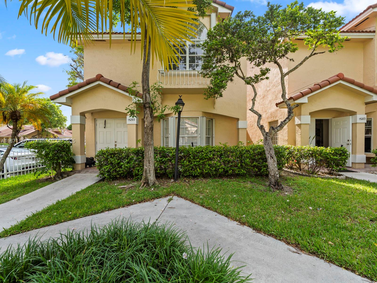 15293 Southwest 111th Street Miami, FL 33196 - Photo 11 of 32 a front view of a house with a yard and potted plants