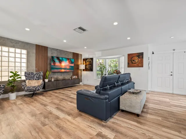a kitchen with stainless steel appliances granite countertop a table chairs in it and wooden floors
