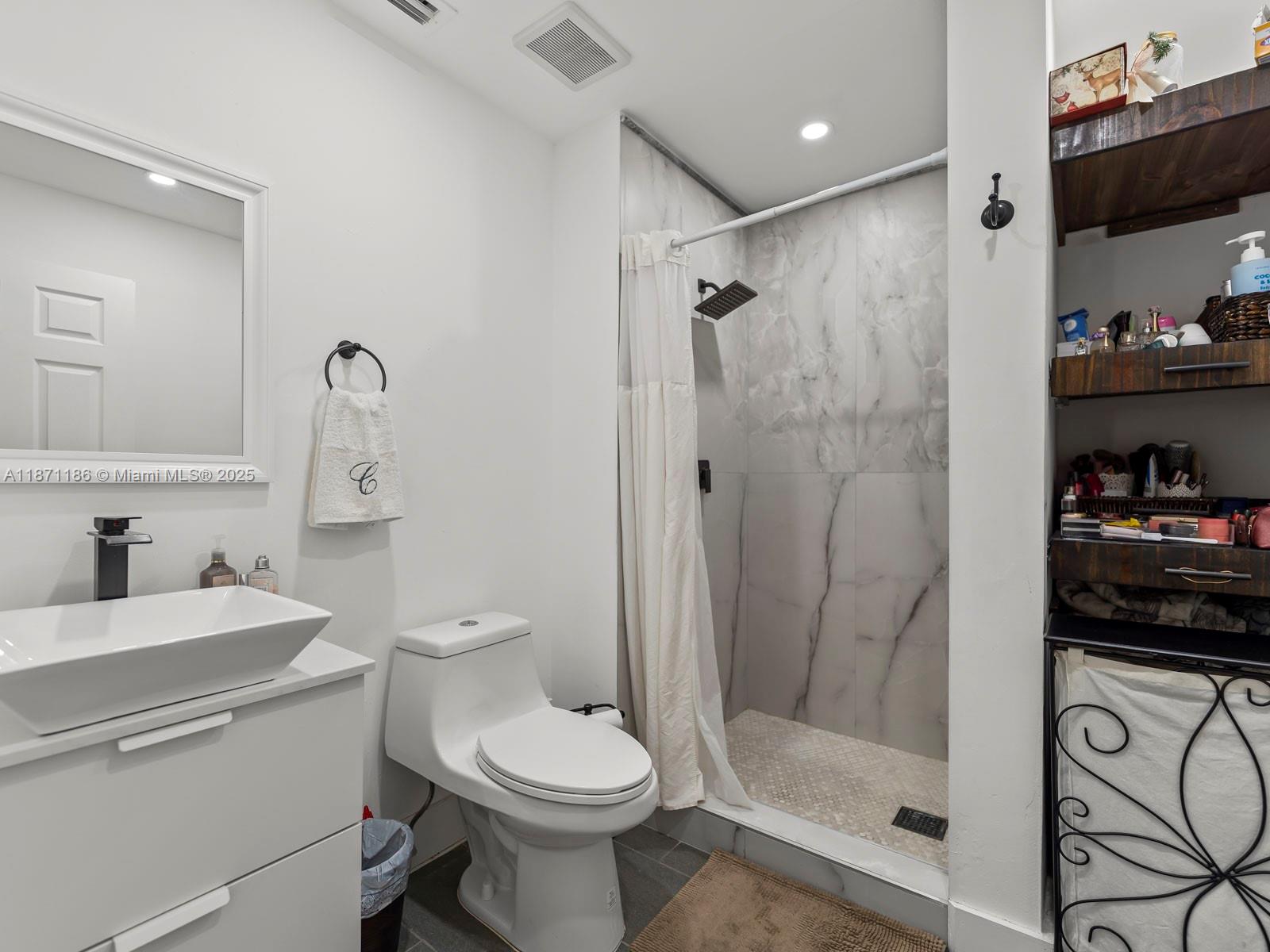 15293 Southwest 111th Street Miami, FL 33196 - Photo 24 of 32 a bathroom with a toilet a sink and shower