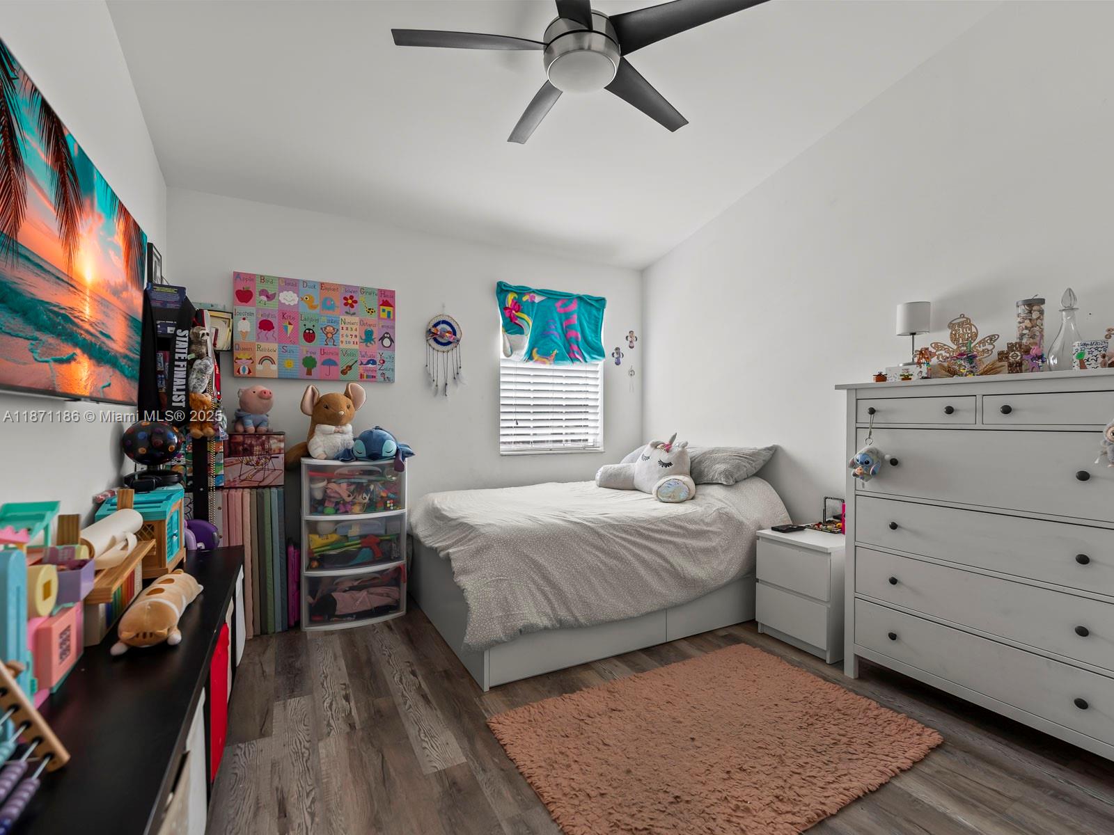 15293 Southwest 111th Street Miami, FL 33196 - Photo 27 of 32 a bedroom with a bed and wooden floor