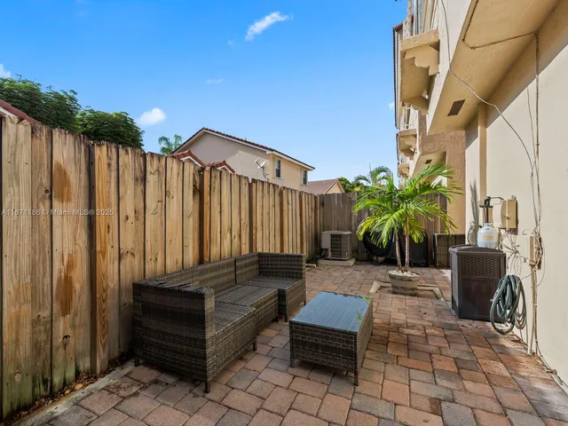 a backyard of a house with barbeque oven table and chairs