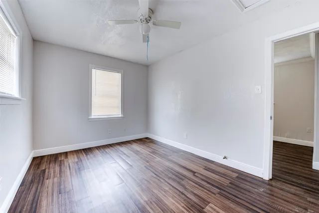 wooden floor in an empty room with a window