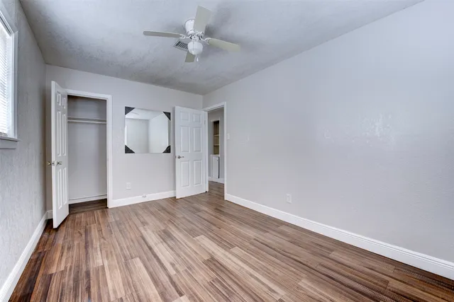 a view of empty room with wooden floor