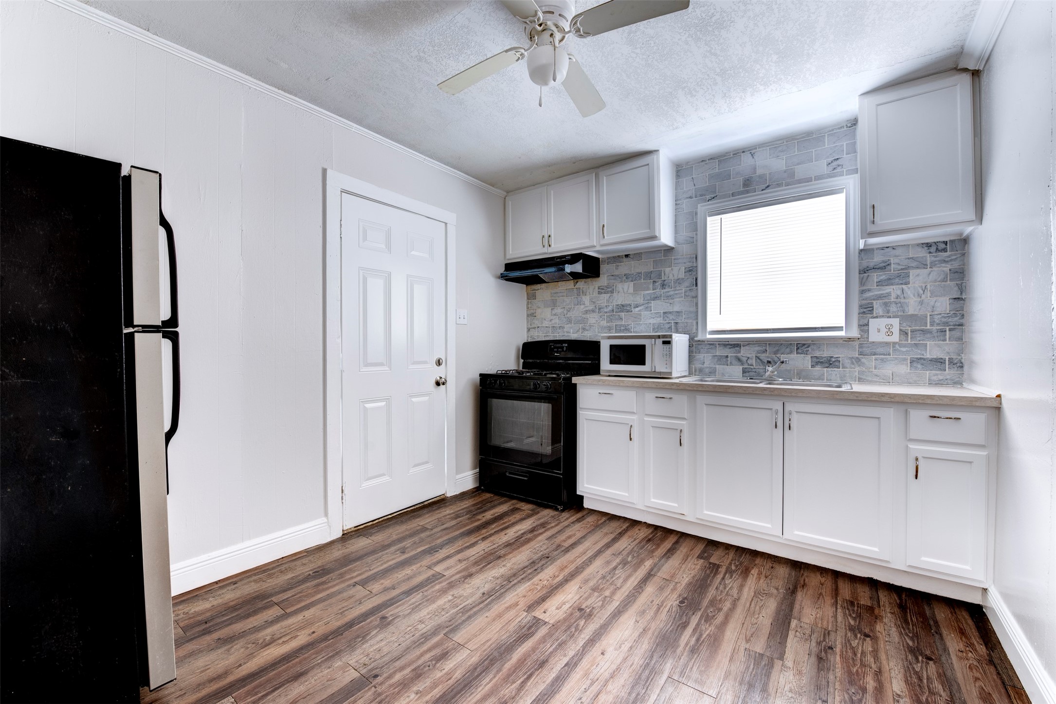 1209 Cabell Street Houston, TX 77022 - Photo 10 of 16 a kitchen with a refrigerator and a stove top oven