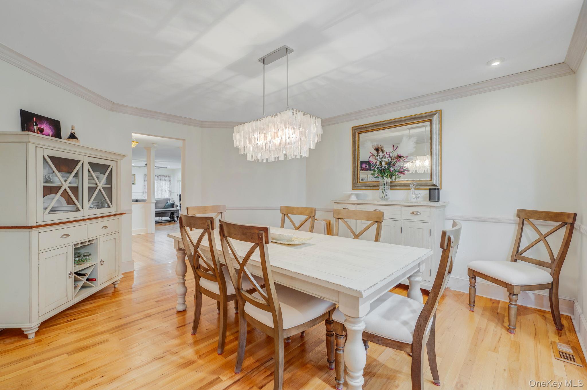 300 Private Road, Unit 8 Cutchogue, NY 11935 - Photo 20 of 47 a view of a dining room with furniture wooden floor and a chandelier