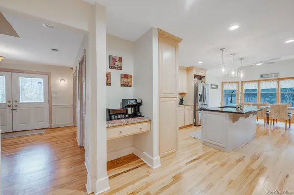 a view of a kitchen with granite countertop a center island a sink stainless steel appliances and cabinets