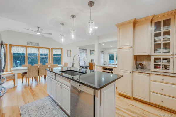 a kitchen with stainless steel appliances granite countertop hardwood floor sink stove and granite counter top